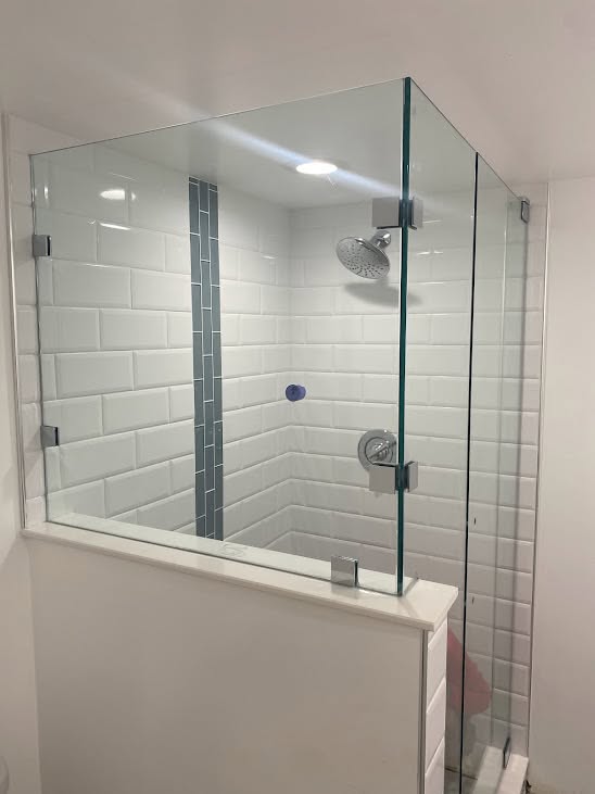 Frameless shower with subway tile and glass mosaic feature stripe