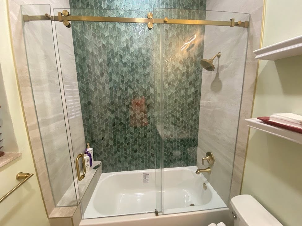 Sliding tub and shower door with brass hardware